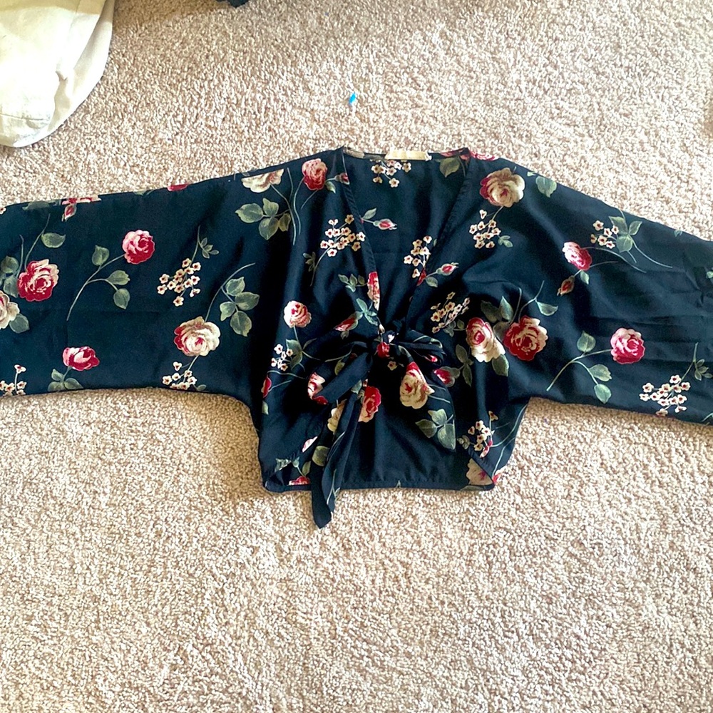 Black cropped tie front blouse with floral pattern.